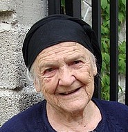 An elderly woman with a wise and loving face